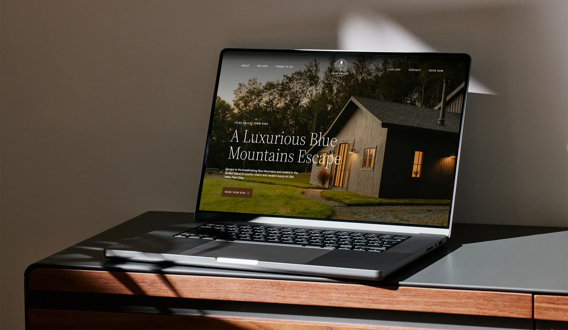The Lilac Valley Farm Stay website displayed on a laptop